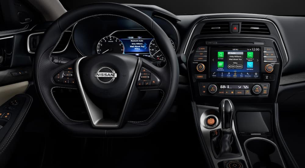 The interior of a 2021 Nissan Maxima shows the steering wheel and infotainment system.