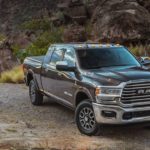 A grey 2021 Ram 2500 is parked on a dirt road in the mountains after reviewing a Ram buyers guide.