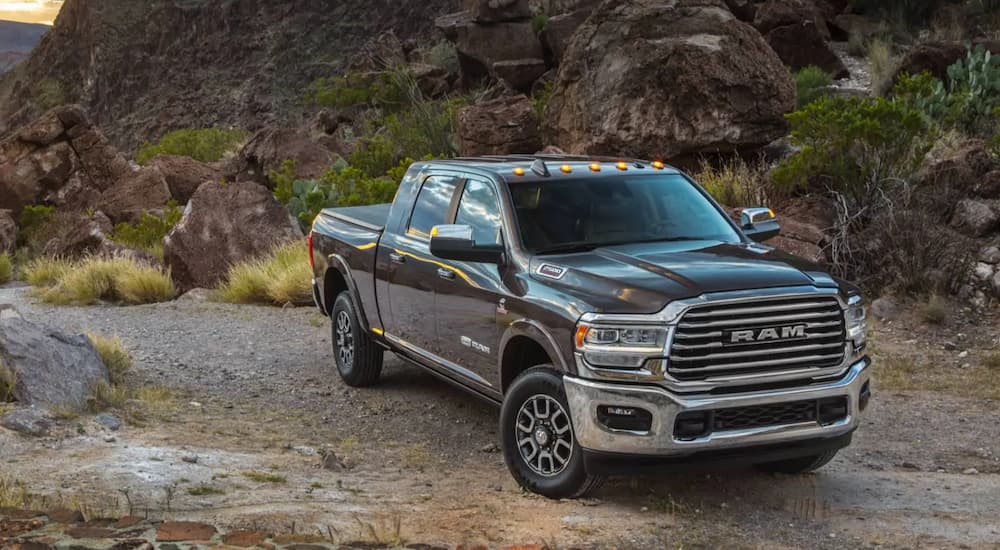 A grey 2021 Ram 2500 is parked on a dirt road in the mountains after reviewing a Ram buyers guide.