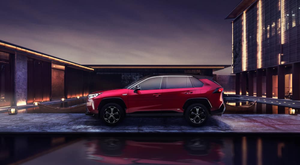 A red 2021 Toyota RAV4 Prime is parked in a modern compound.