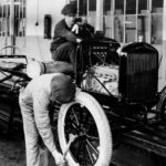 A 1924 Ford Model-T is being constructed on an assembly line.