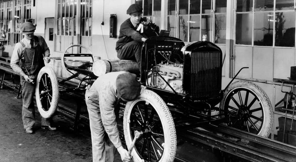 A 1924 Ford Model-T is being constructed on an assembly line.