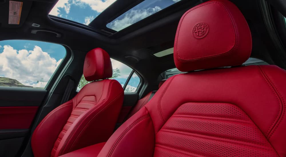 The red interior of a 2020 Alfa Romeo Giulia shows two front seats.