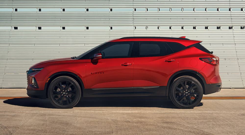 A red 2021 Chevy Blazer is shown from the side parked in front of a white wall after winning a 2021 Chevy Blazer vs 2021 Honda Passport comparison.