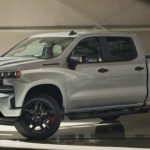 A silver 2021 Chevy Silverado 1500 is parked in a modern gallery after winning a 2021 Chevy Silverado vs 2021 Ford F-150 comparison.