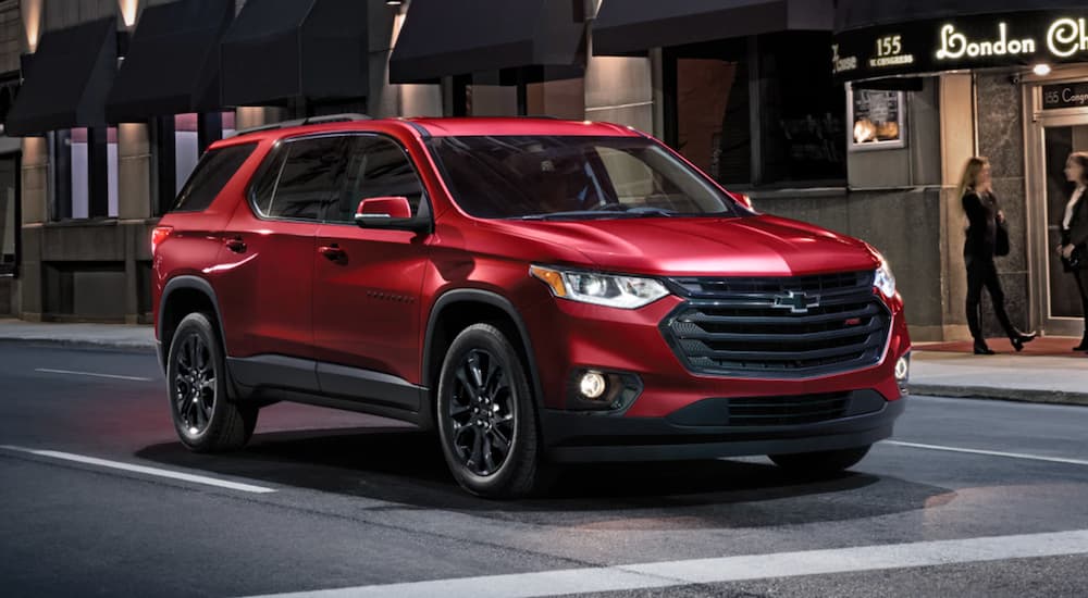 A red 2021 Chevy Traverse is stopped at a red light in the city.