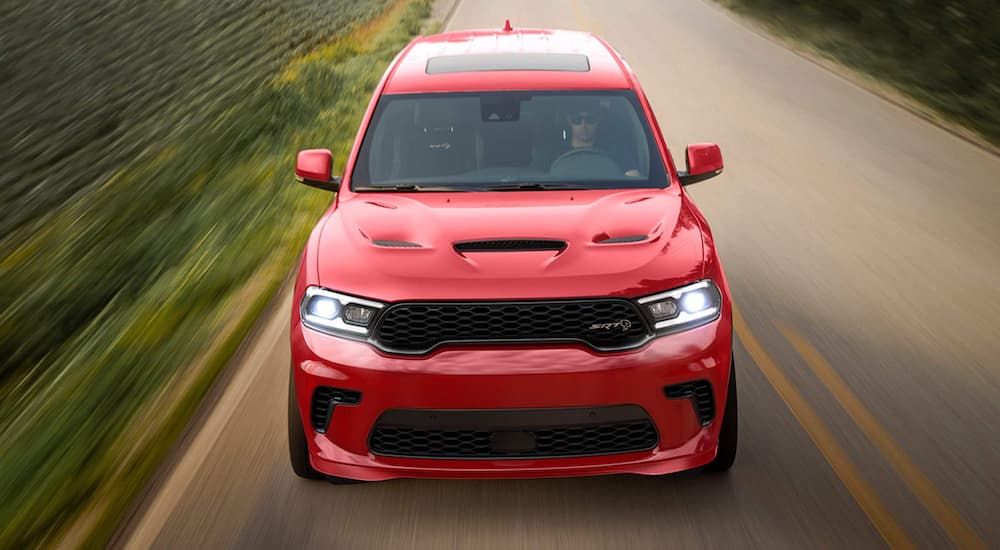 A red 2021 Dodge Durango is shown from the front driving down a two way road after winning a 2021 Dodge Durango vs 2021 Kia Sorento comparison.