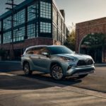 A grey 2021 Toyota Highlander is driving through a city after winning a 2021 Toyota Highlander vs 2021 Chevy Traverse comparison.