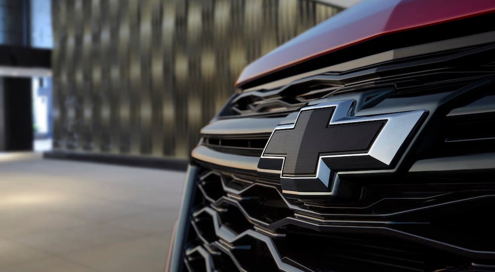 The front of a red 2022 Chevy Equinox shows a close up of the Chevy bowtie.