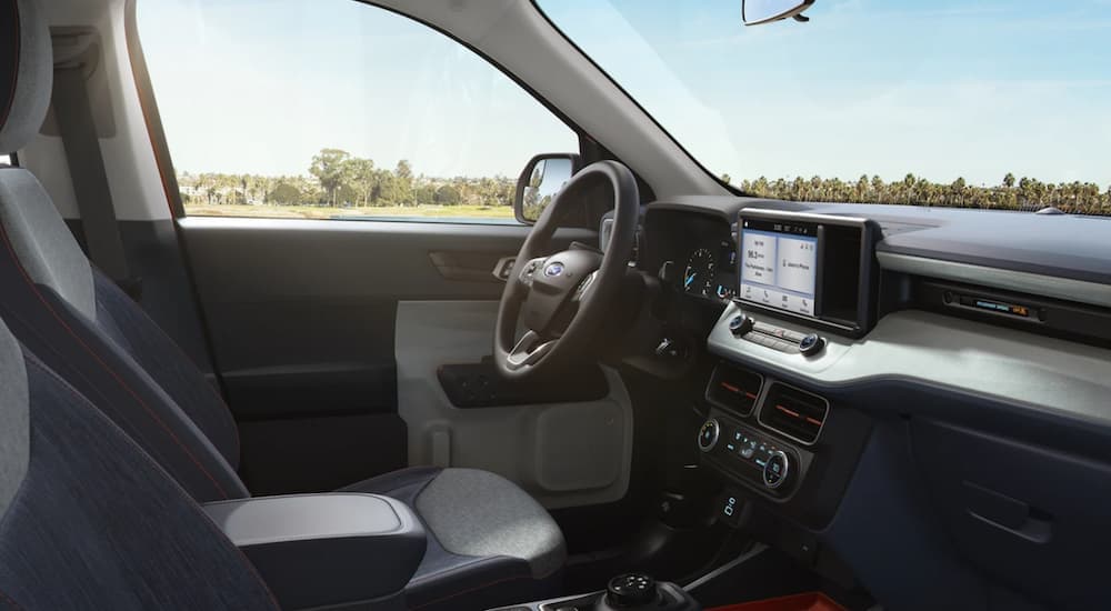 The interior of a 2022 Ford Maverick shows the steering wheel and infotainment screen.