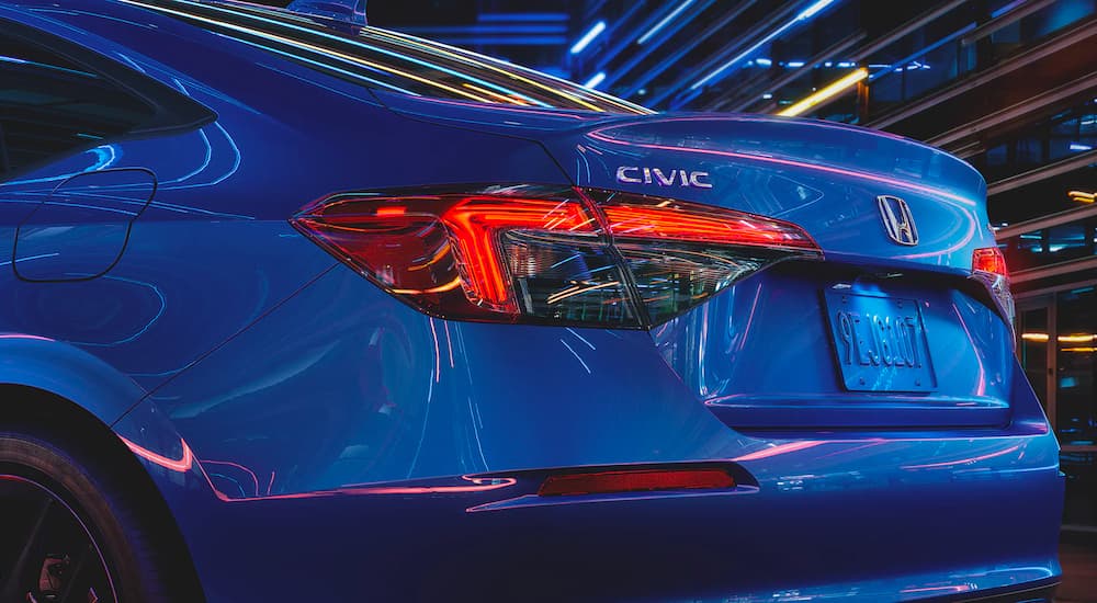 A close up shows the rear tail lights and badges on a blue 2022 Honda Civic Sport.
