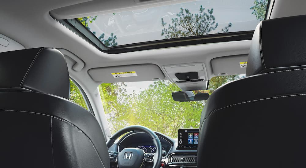 The moonroof and front seats are shown from a low angle in a 2022 Honda Civic Touring.
