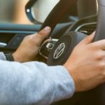 A close up shows hands on the steering wheel of a 2022 Volkswagen Golf GTI.