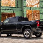 A black 2022 Chevy Silverado 1500 HD is shown from the side at a construction site after leaving a Chevy dealer.