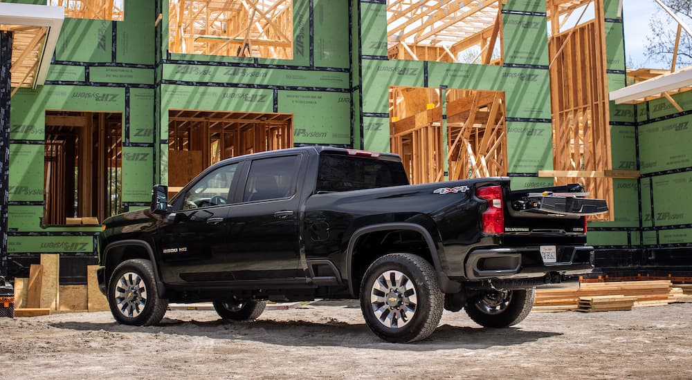 A black 2022 Chevy Silverado 1500 HD is shown from the side at a construction site after leaving a Chevy dealer.
