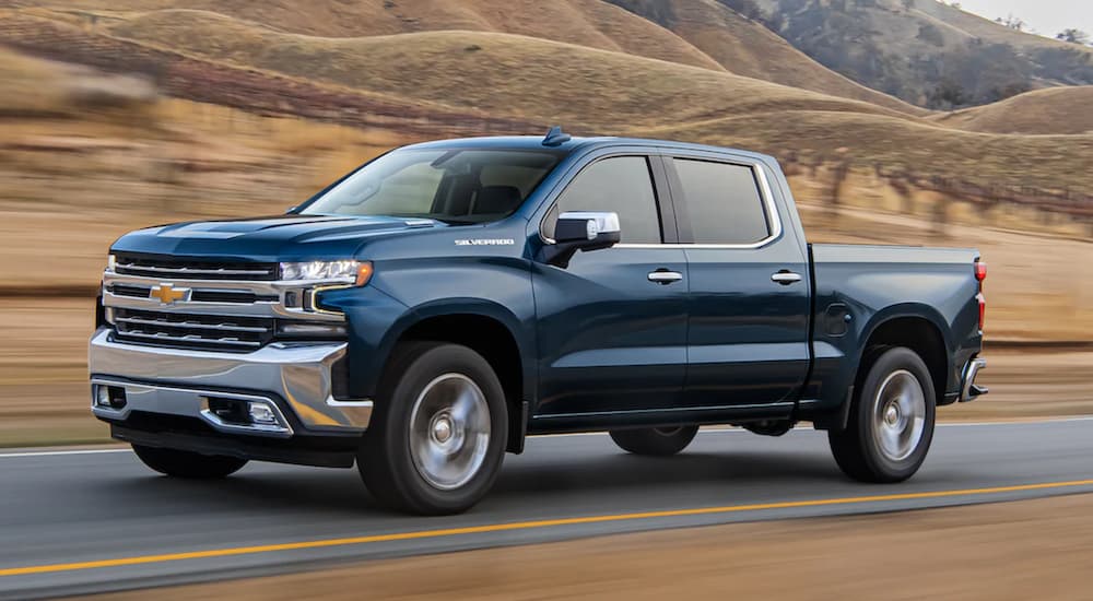 A 2020 Chevy Silverado 1500 is driving on a road past a vineyard.