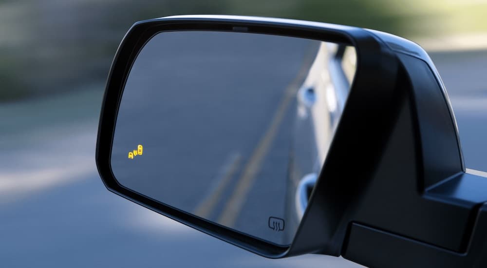 A close up shows the illuminated blind spot monitoring icon on a 2021 Toyota Sequoia.