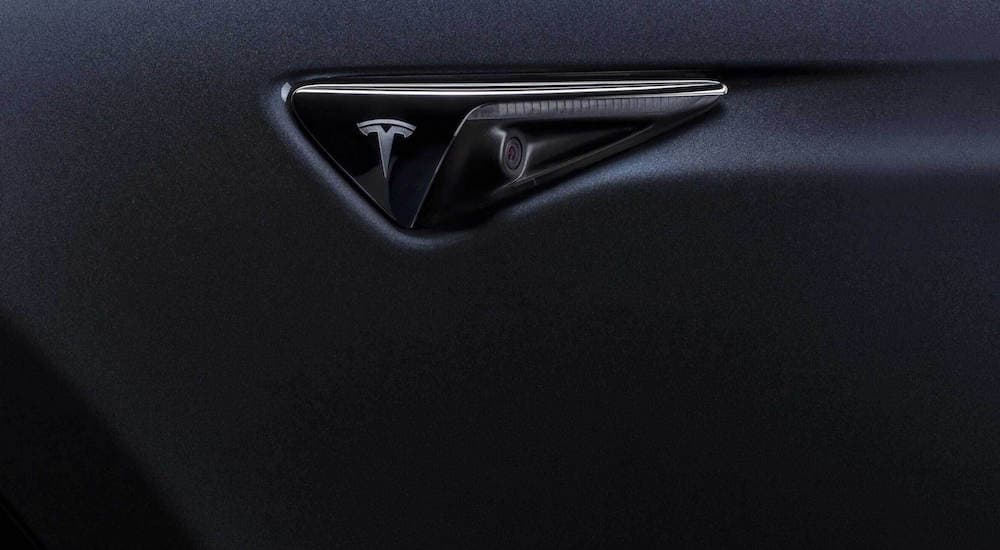 A close up shows a Tesla autopilot camera.