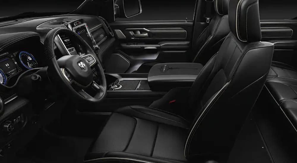 The black interior of a 2021 Ram 1500 shows the front seats.