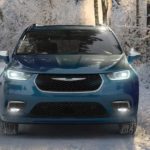 A blue 2020 used Chrysler Pacifica Hybrid is parked in the snowy woods after leaving a used Chrysler Pacifica Hybrid dealer.