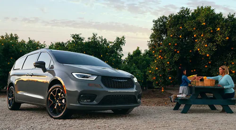 A grey 2020 used Chrysler Pacifica Hybrid is parked next to a picnic bench.