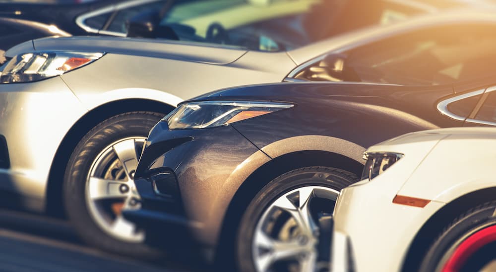 A line of cars is shown parked at a used car lot.