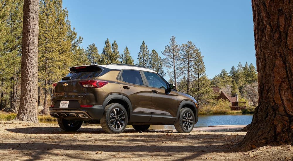 A gold 2021 Chevy Trailblazer ACTIV is shown parked next to a lake.