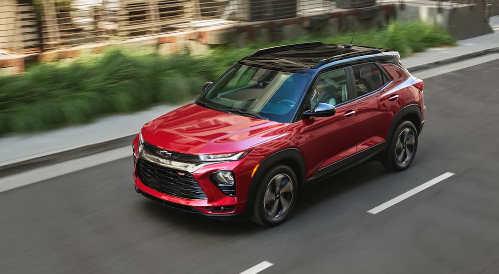 A red 2021 Chevy Trailblazer is shown from a high angle driving down a city road.