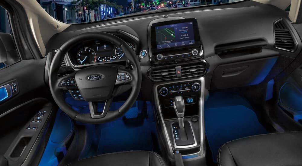 The interior of a 2021 Ford EcoSport shows the steering wheel and infotainment screen.