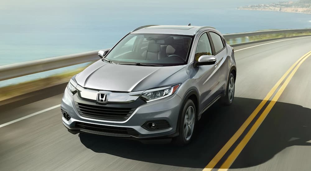 A grey 2021 Honda HR-V EX-L is shown from the fornt driving next to an ocean.