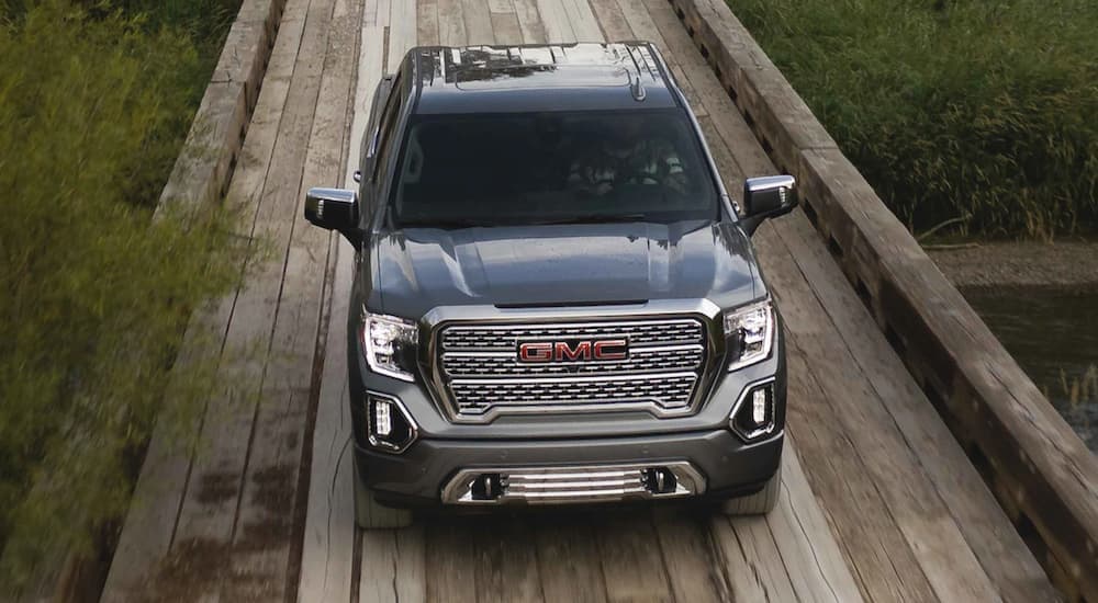 A grey 2021 GMC Sierra 1500 is shown from above driving on a boardwalk.