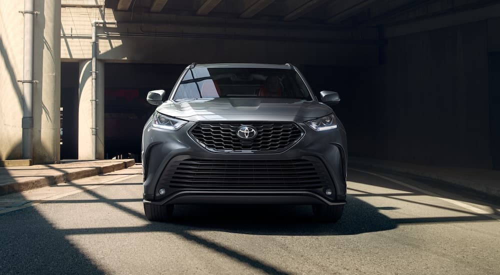 A grey 2021 Toyota Highlander XSE is shown from the front parked partially in shadows.