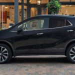 A black 2022 Buick Encore is shown form the side parked in front of a boutique.