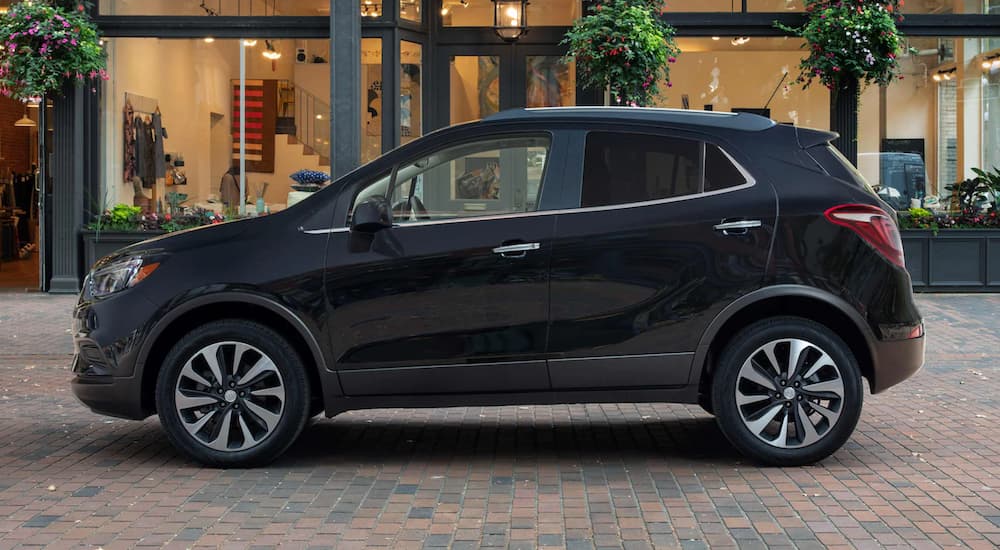 A black 2022 Buick Encore is shown form the side parked in front of a boutique.