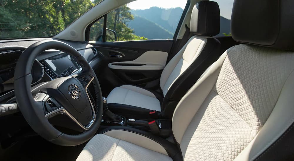 The black and white interior of a shows the steering wheel and front seats.