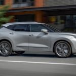 A silver 2022 Chevy Blazer is shown from the side driving through a city.