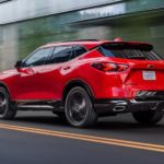 A red 2022 Chevy Blazer RS is shown from the rear driving through a city.