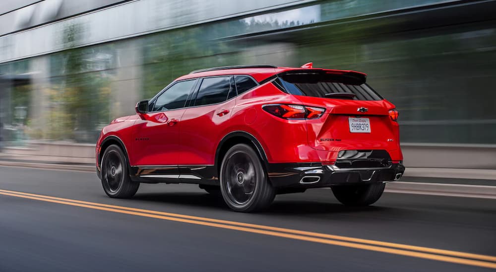 A red 2022 Chevy Blazer RS is shown from the rear driving through a city.