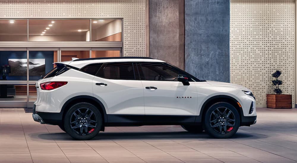 A white 2021 Chevy Blazer Redline Edition is shown from the side parked in front of a modern building.