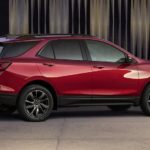 A red 2022 Chevy Equinox is shown from the side parked in a gallery.