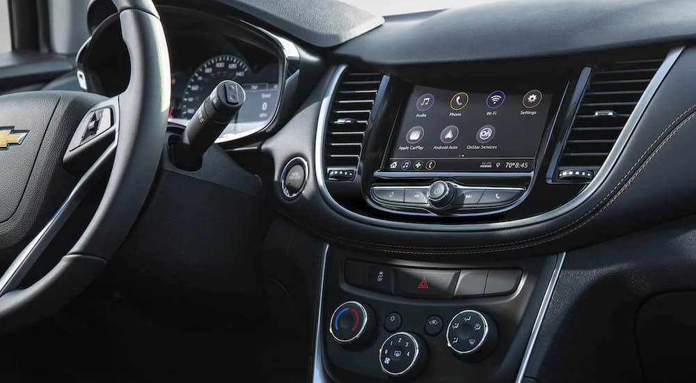 The black interior of a 2022 Chevy Trax shows the infotainment screen.