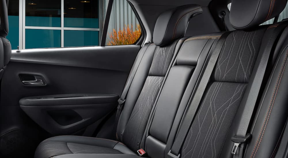 The black interior of a 2022 Chevy Trax shows three seats.