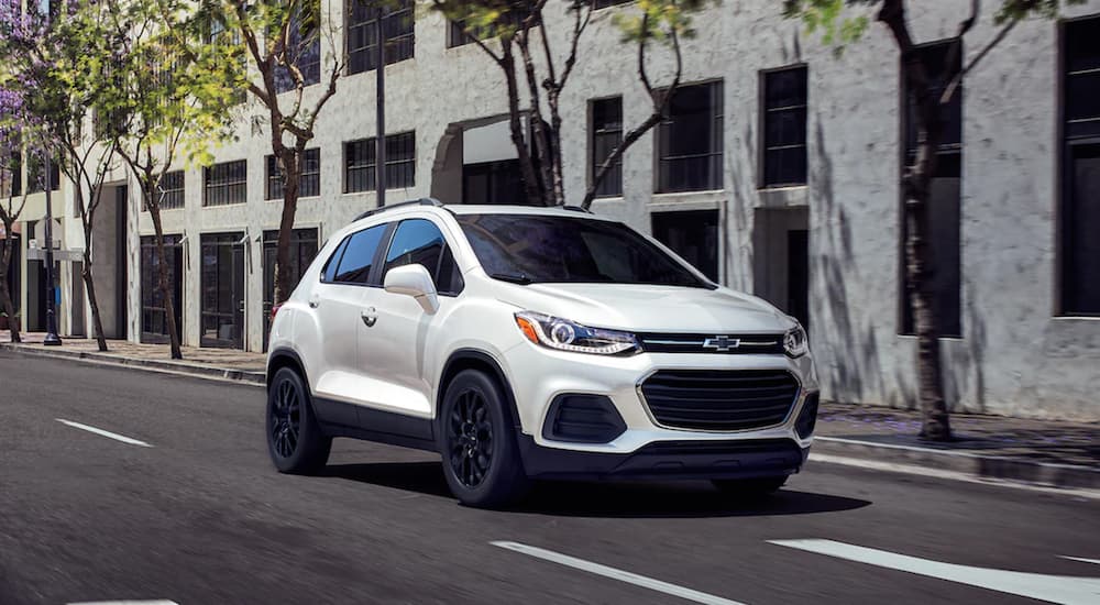 A white 2022 Chevy Trax is shown driving through a city.