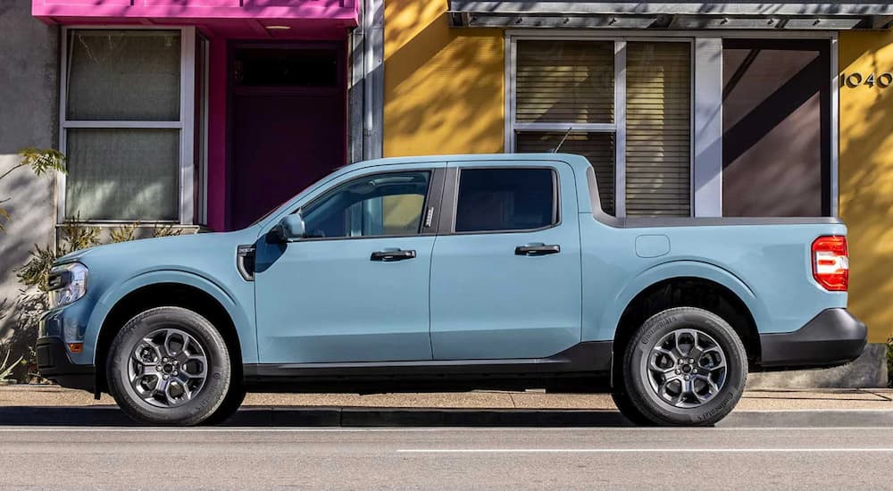A light blue 2022 Ford Maverick is shown from the side parked on a city street after winning a 2022 Ford Maverick vs 2022 Hyundai Santa Cruz comparison.