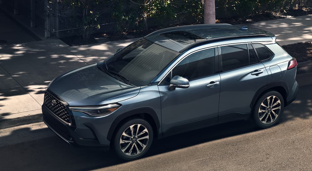 A blue 2022 Toyota Corolla Cross is shown parked on a city street.