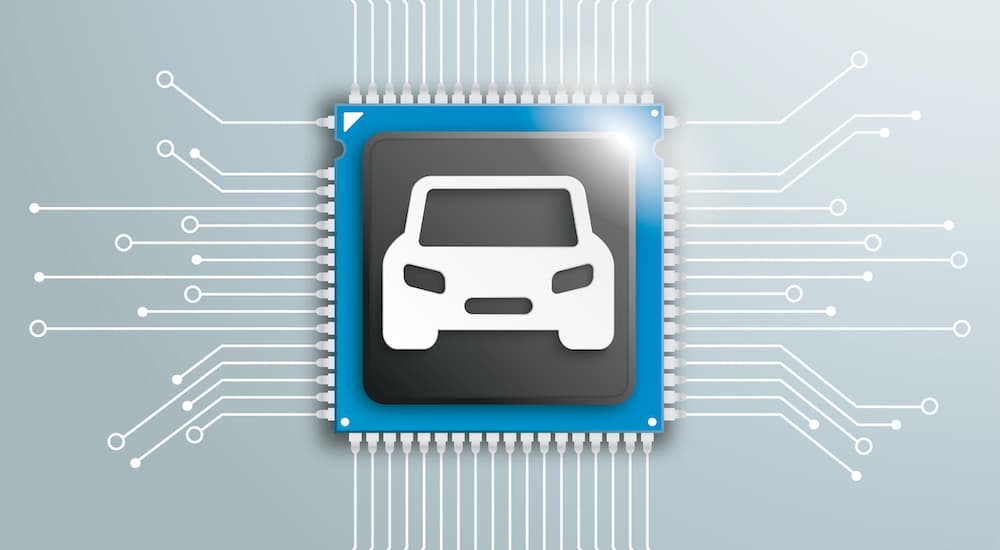 A close up shows the white outline of a car on a microchip.