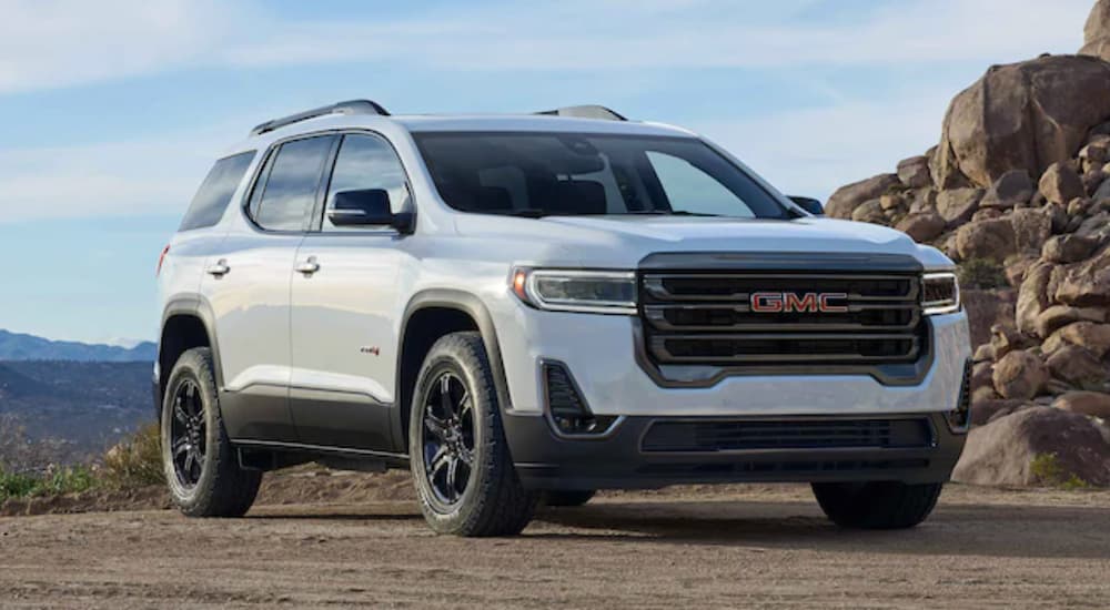 A white 2022 GMC Acadia AT4 is shown parked in the mountains.