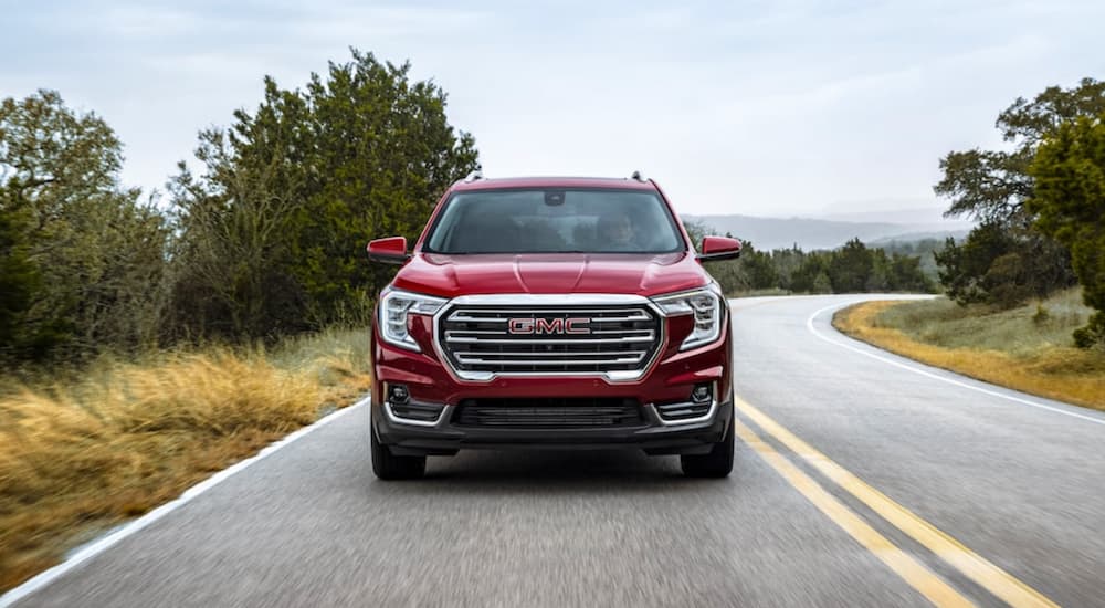 A red 2022 GMC Terrain is shown from the front driving on an open road.