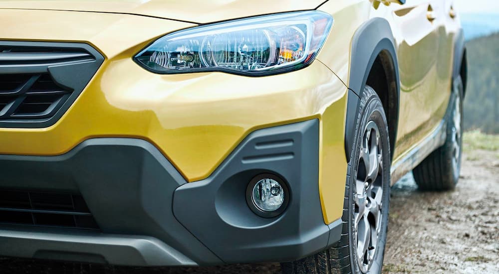 A close up shows the driver side headlight and bumper on a yellow 2021 Subaru Crosstrek after leaving a Staten Island Subaru dealer.