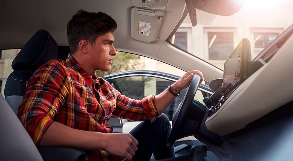 A driver is shown in a 2022 Toyota Corolla Hybrid LE after leaving a Toyota dealer near you.